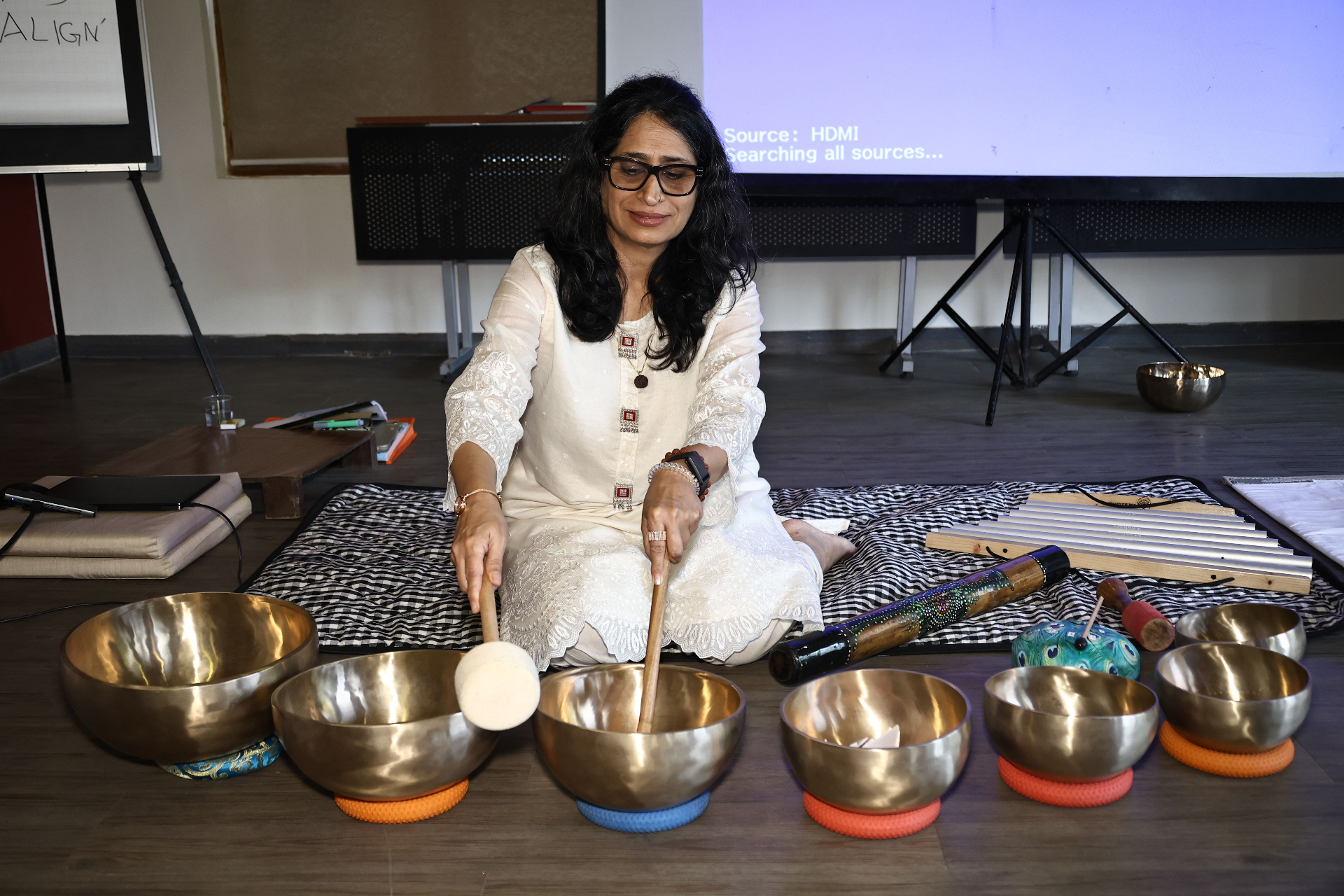 Vandana Raj playing singing bowls during a Divine Whisper healing session
